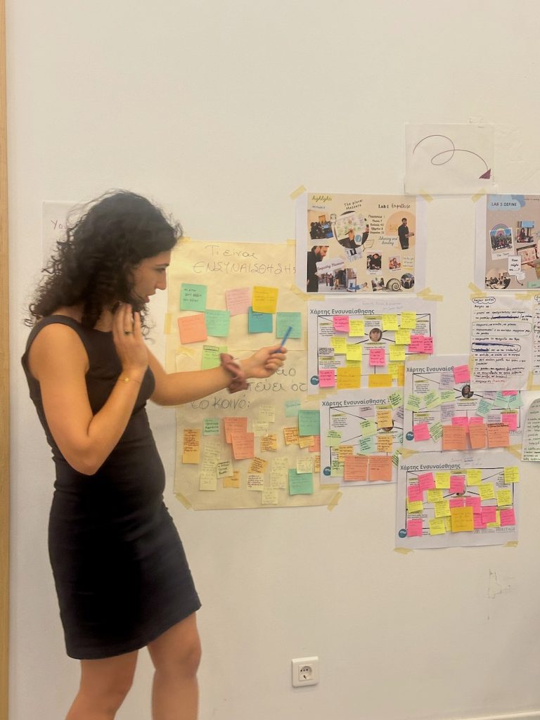 Woman in front of wall covered with post it notes and photos.