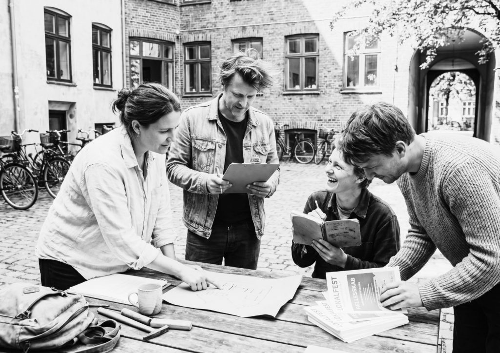 Team of people working together over a table.